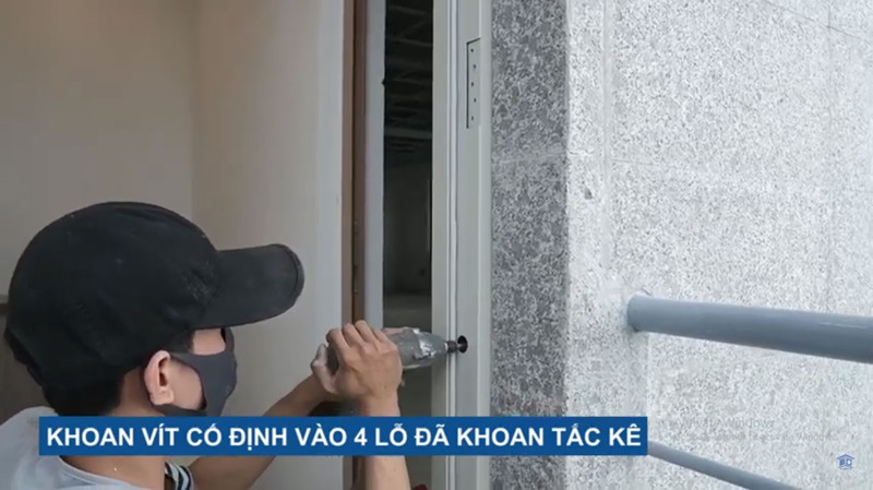 Dùng khoan vít cố định khung cửa vào tường cho chắc chắn