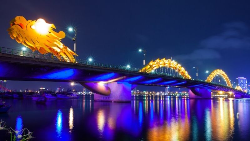 Dragon Bridge in Danang Vietnam lit up at night with colorful lights and fire-breathing show