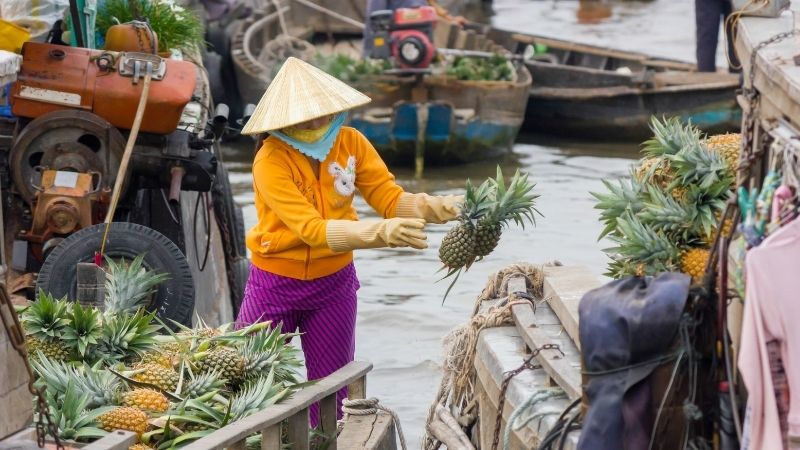 Local vendors selling fruit and noodles at Cai Rang Floating Market on a Ho Chi Minh to Mekong Delta trip