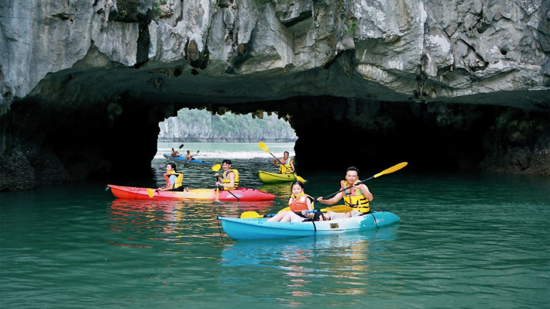 Travelers kayaking through hidden lagoons on a Halong Bay cruise overnight
