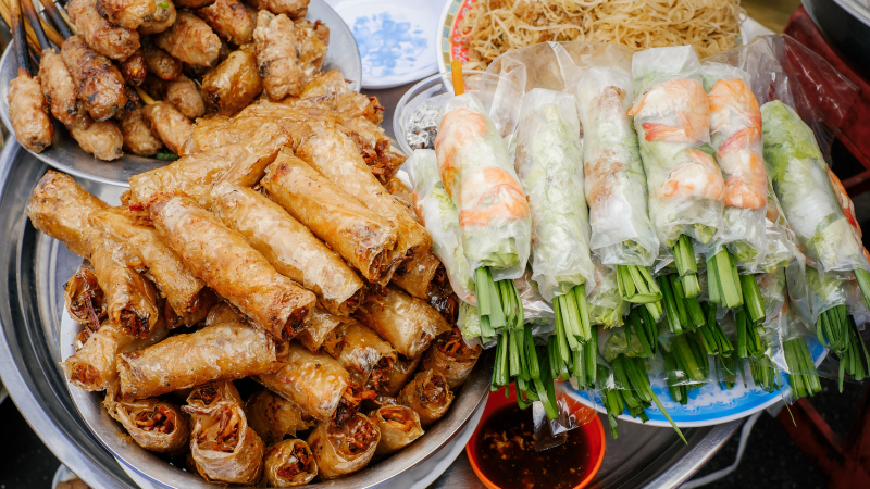 Hanoi Street Food Tour: A Flavorful Journey Through the Capital’s Best Local Eats 2 Hanoi Old Quarter street food stalls with tourists enjoying local dishes