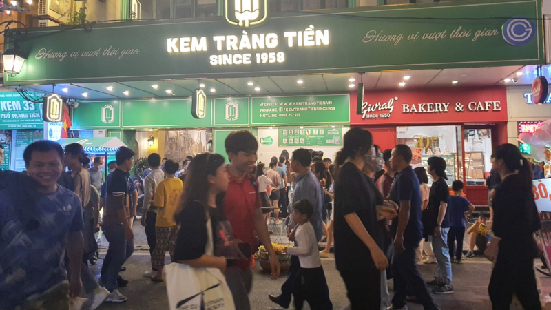 Hanoi Street Food Tour: A Flavorful Journey Through the Capital’s Best Local Eats 5 People enjoying Trang Tien ice cream outside the famous Hanoi ice cream shop