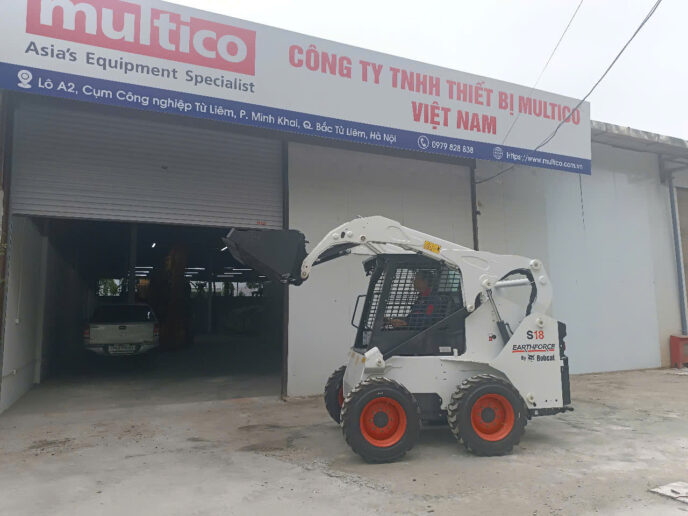 Máy Xúc Mini Bobcat Cho Công Trình Dân Dụng Giải Pháp Hiệu Quả Từ Multico Việt Nam Ảnh máy xúc lật Bobcat S18 sẵn có trong kho Multico Việt Nam thể hiện thiết bị với thiết kế nhỏ gọn, hiện đại, phù hợp cho các công trình dân dụng và những khu vực có không gian làm việc hạn chế. Máy được trưng bày trong điều kiện bảo quản tốt, sẵn sàng để giao ngay, đảm bảo chất lượng và hiệu suất vận hành cao. Đây là lựa chọn tối ưu cho khách hàng cần thiết bị linh hoạt, dễ sử dụng và tiết kiệm chi phí cho các dự án thi công đa dạng.